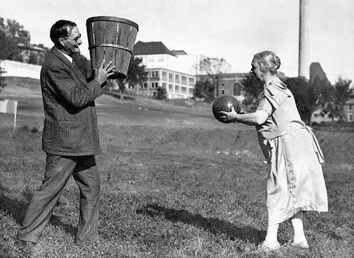 James Naismith trzyma kosz podczas gry w koszykówkę